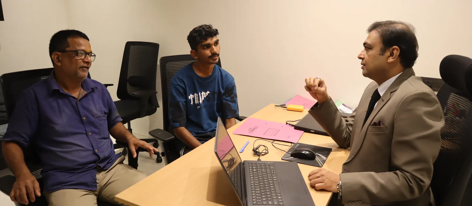 A counsellor talking a student and their father through the course at an IESP centre
