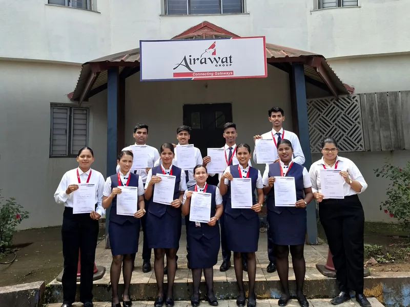 IESP students in uniform holding their certificates outside the IESP centre building