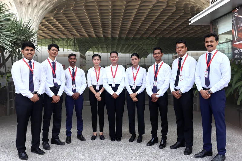 A group in uniform under the canopy at Mumbai International Airport