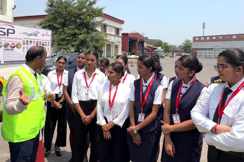 A trainer in a high visibility vest with a group of students in uniform outdoors